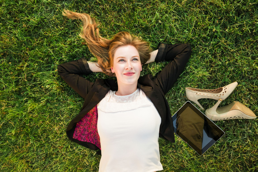 Young,Independent,Woman,Relaxing,On,Grass,In,Park